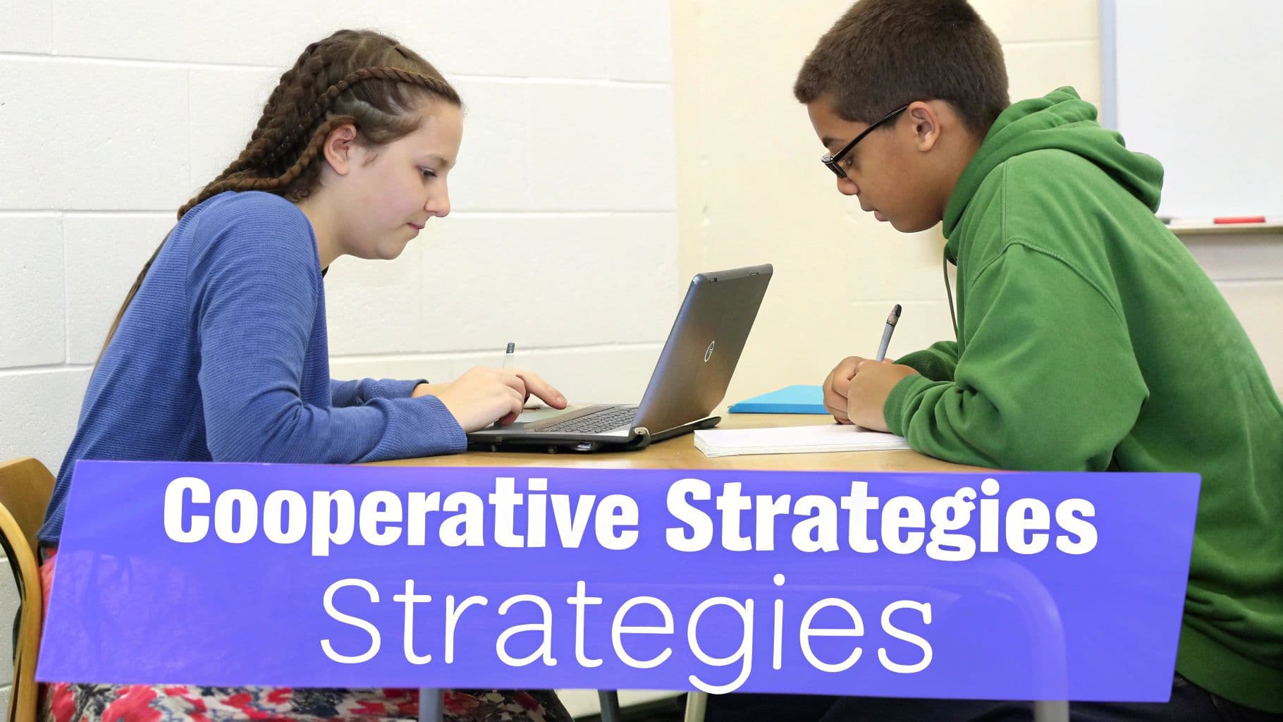 Two students, a girl and a boy, diligently work on assignments at a desk in a classroom.