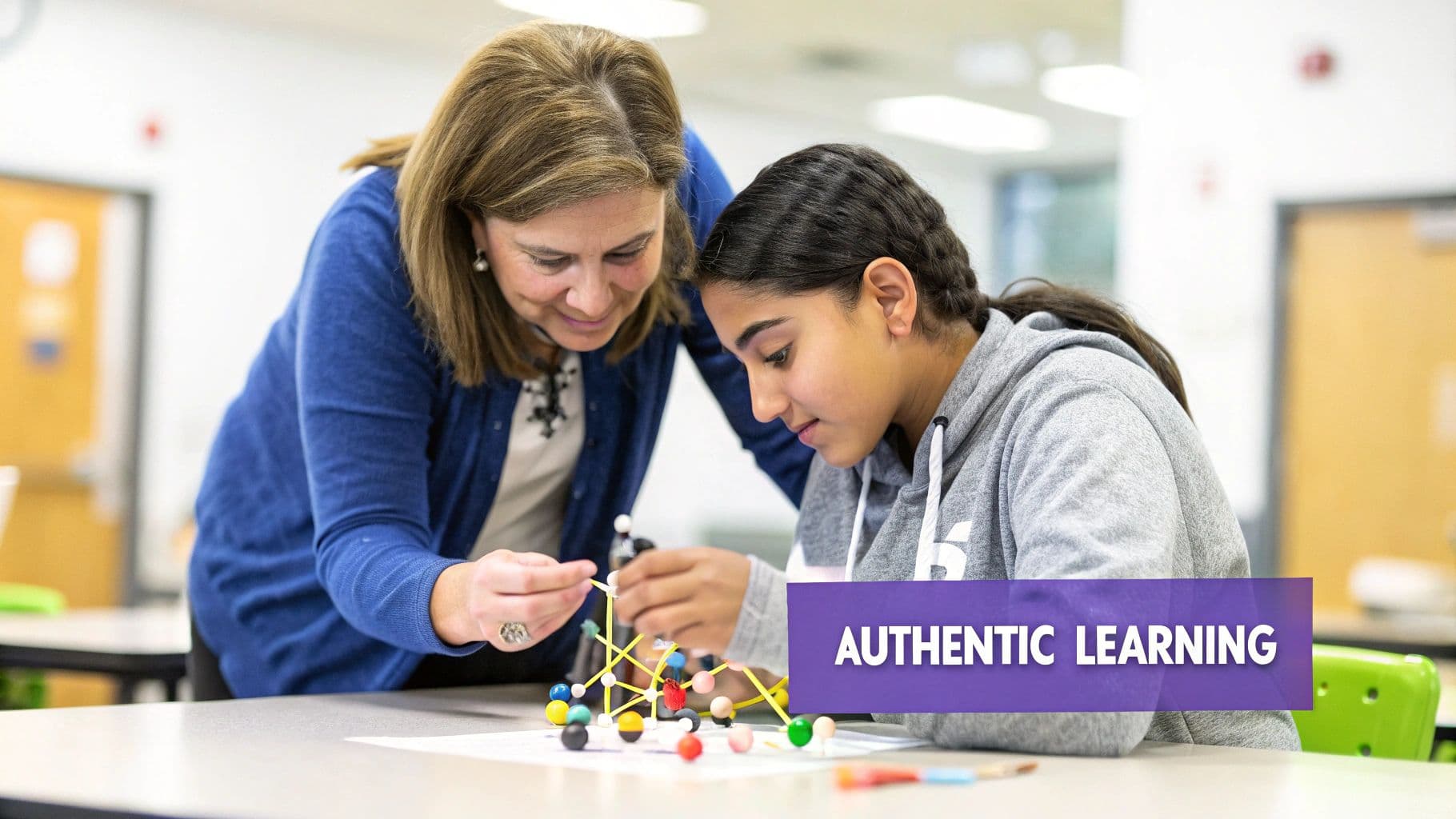 A female teacher guides a student in building a complex molecular model during a STEM project.