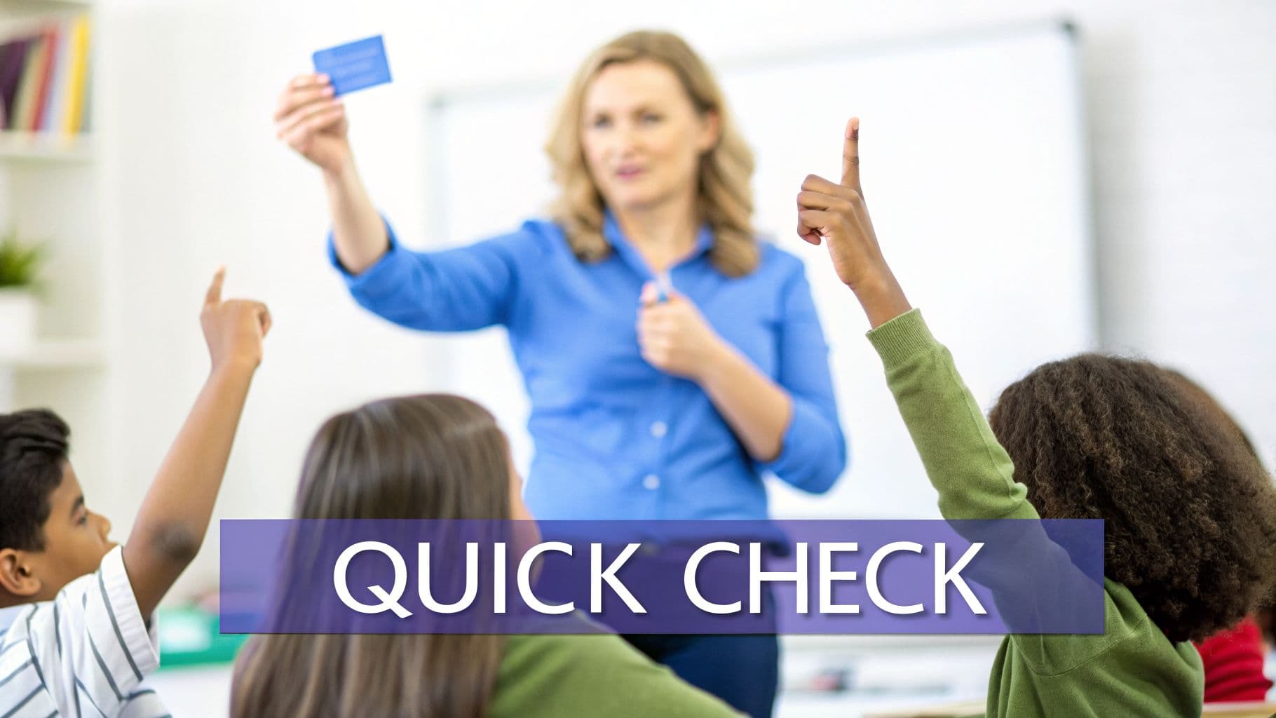 A teacher holds up a card while students raise their hands, performing a quick check in class.