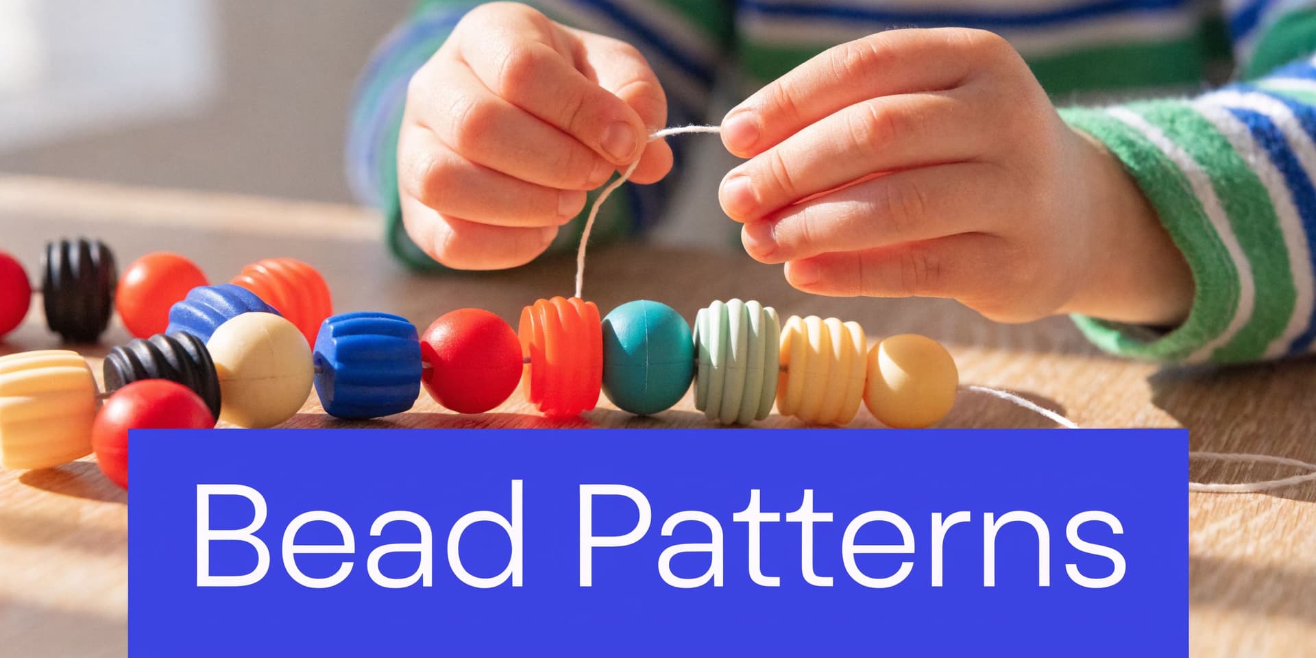 A young child strings colorful textured plastic beads onto a piece of white yarn to create patterns.