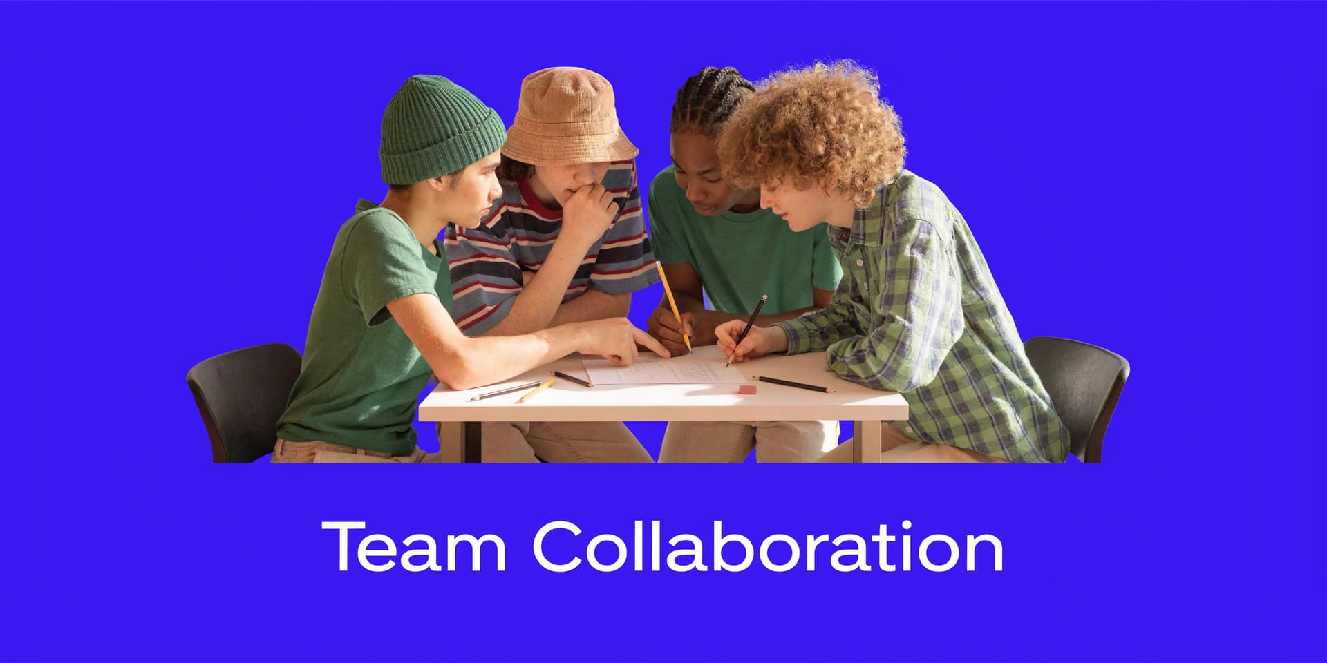 A diverse group of four students collaborating together around a table while working on a school assignment.