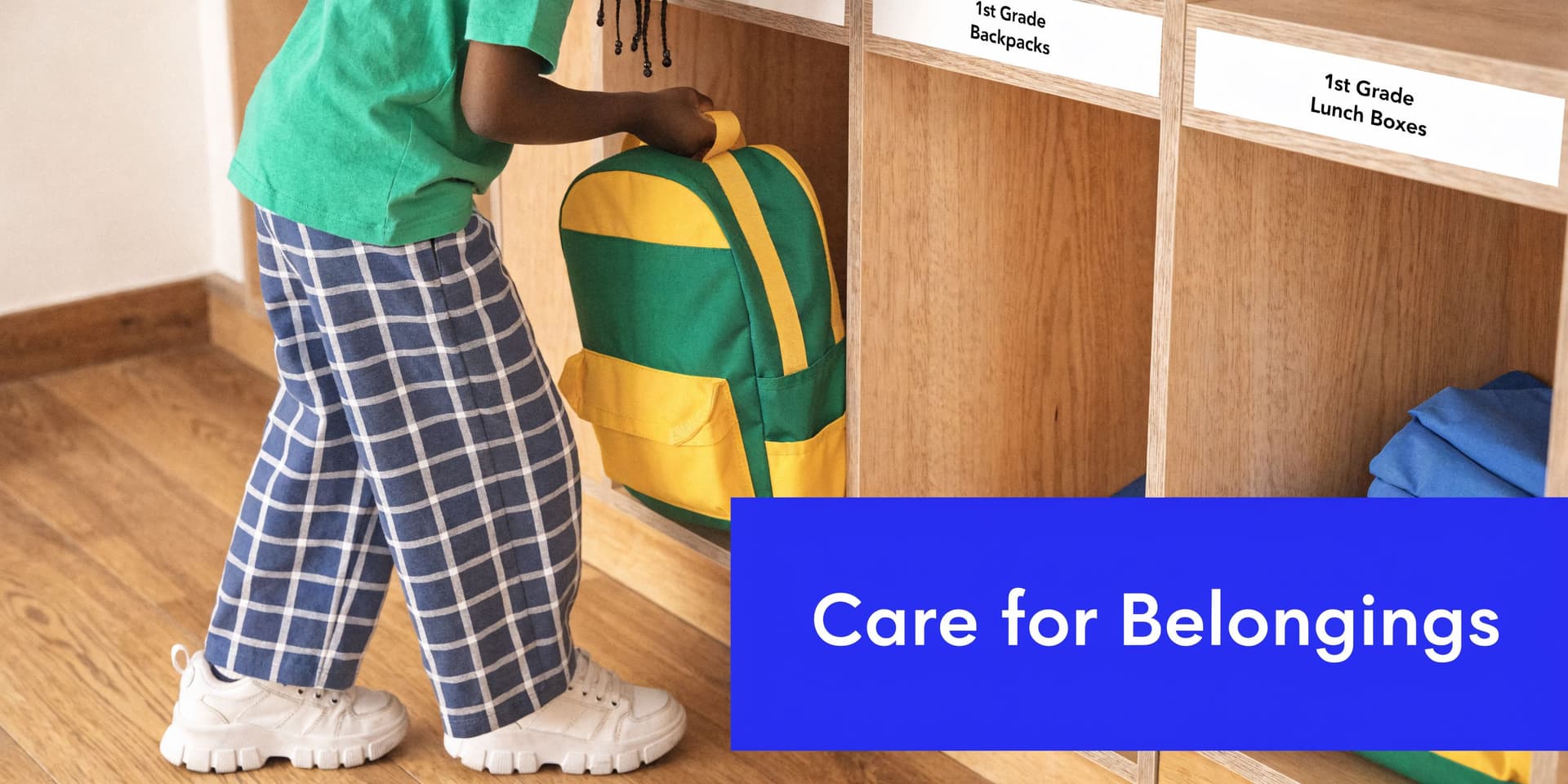 A first grade student places their backpack into a designated wooden cubby in the classroom.